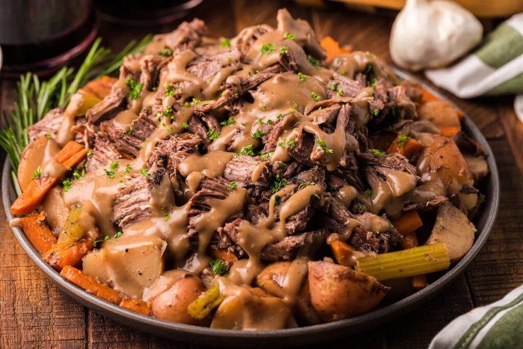A bowl of pot roast with red wine.