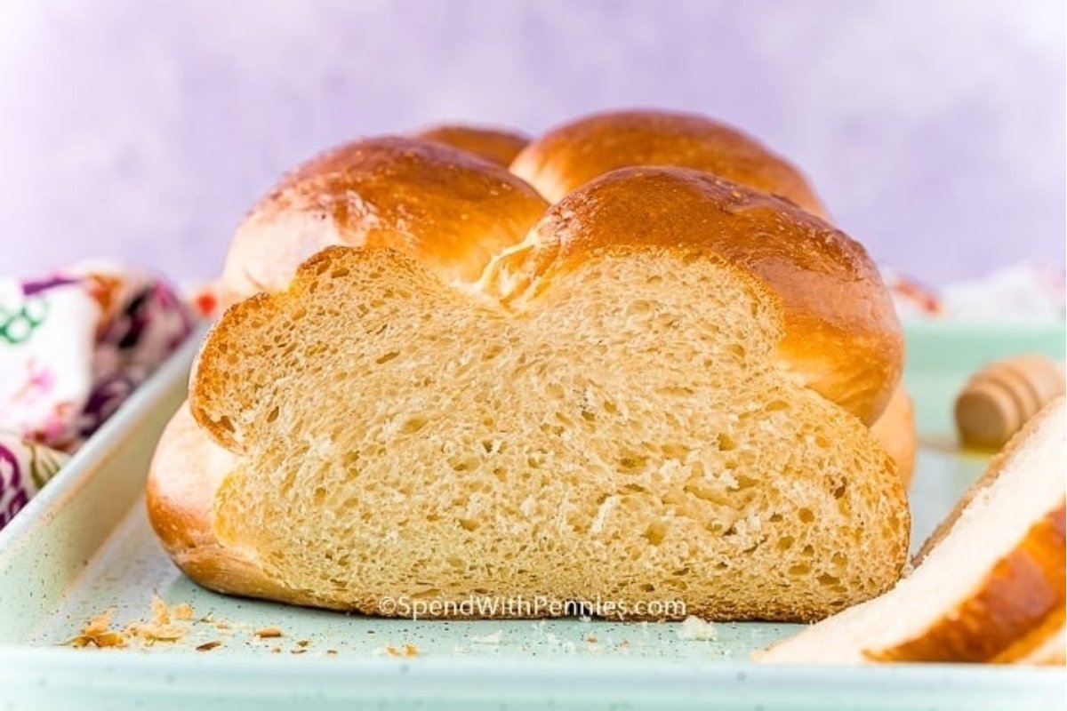 A loaf of bread, inspired by bread recipes, on a plate with honey on it.
