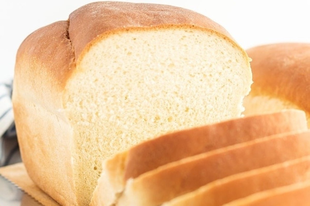A loaf of white bread on a cutting board, perfect for various bread recipes.