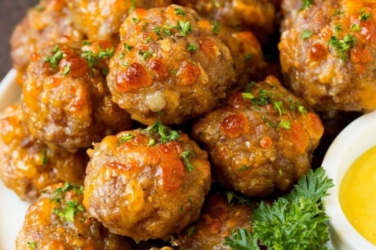 Meatballs on a white plate with Bisquick recipes dipping sauce.