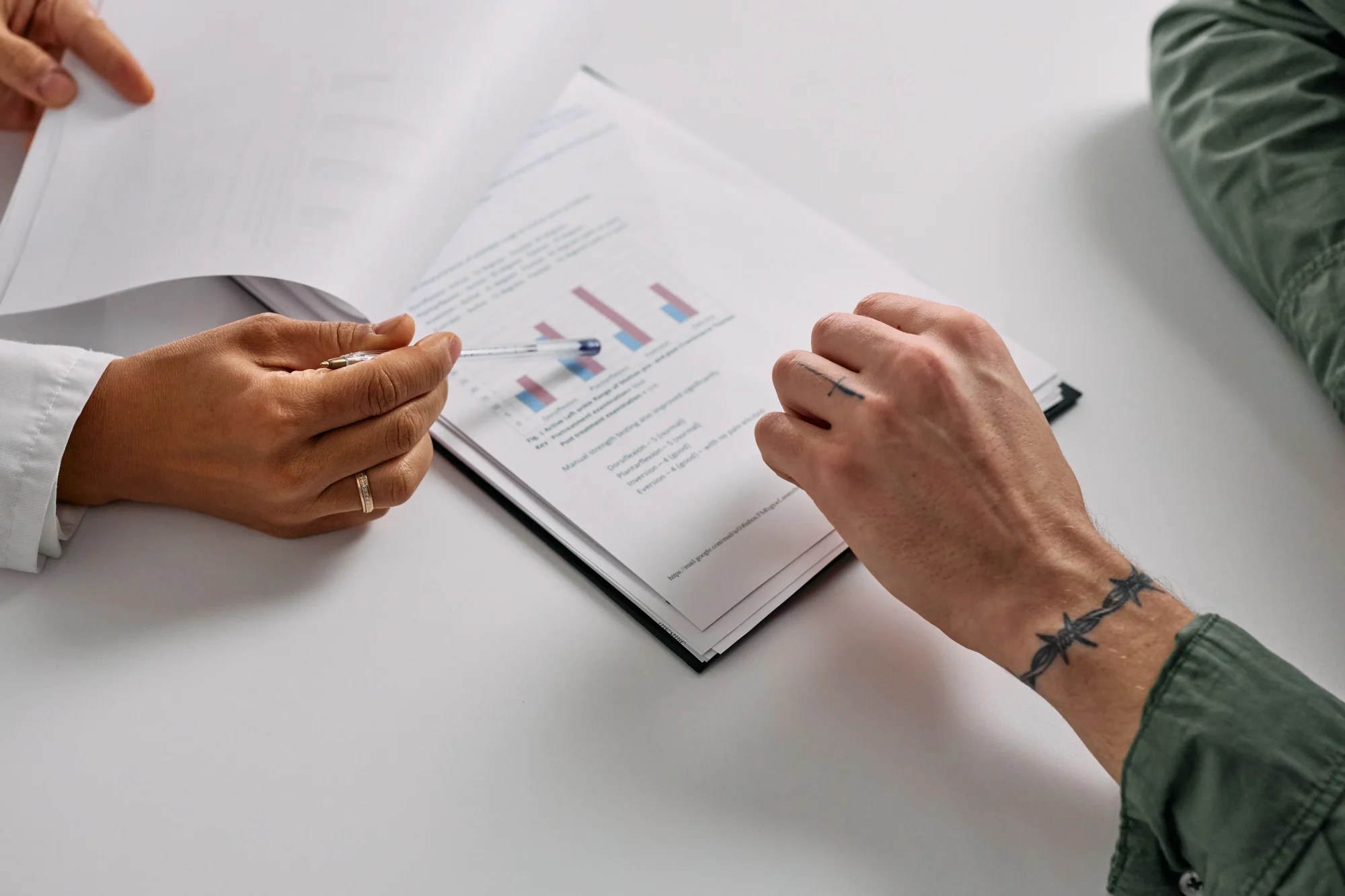 Two professionals analysing commercial data and charts during a business planning discussion