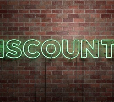 DISCOUNTS - fluorescent Neon tube Sign on brickwork