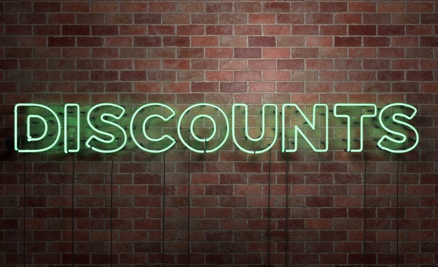 DISCOUNTS - fluorescent Neon tube Sign on brickwork