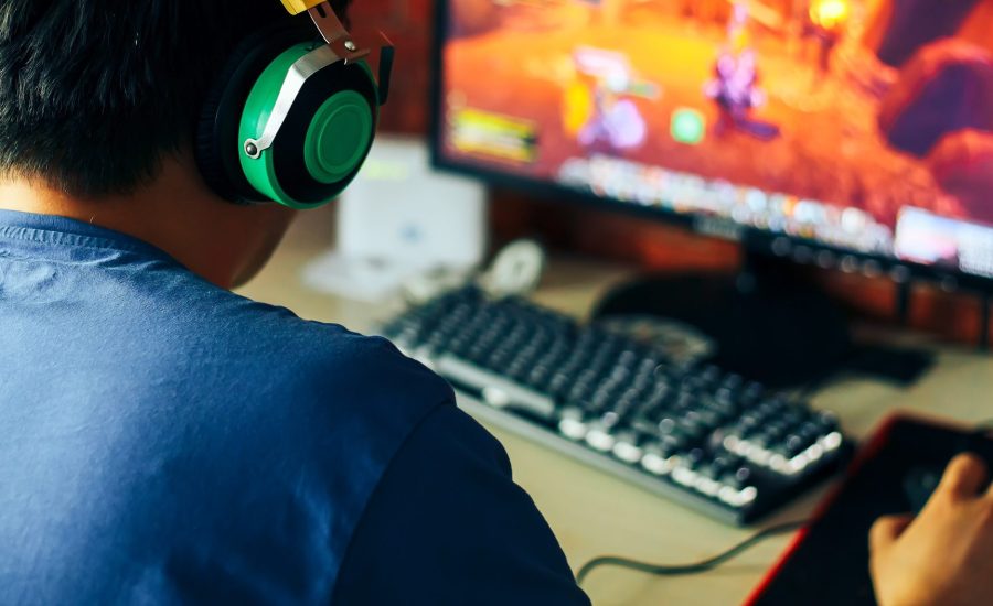 young man playing game on computer, banner