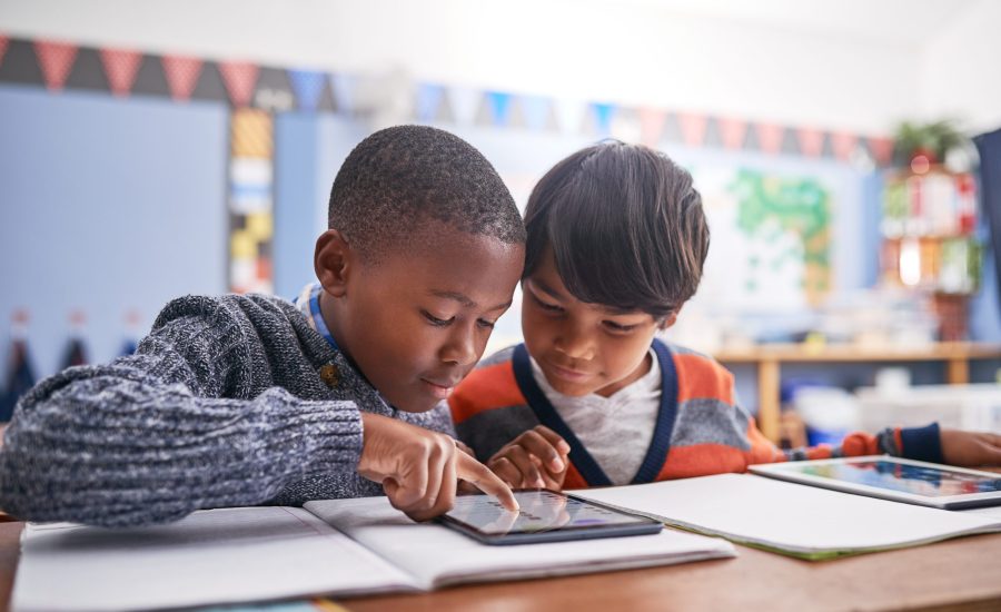 Digital tablet, school and students in classroom doing research for work, test or exam. Technology, education and boy children friends working on project or assignment together with mobile on campus