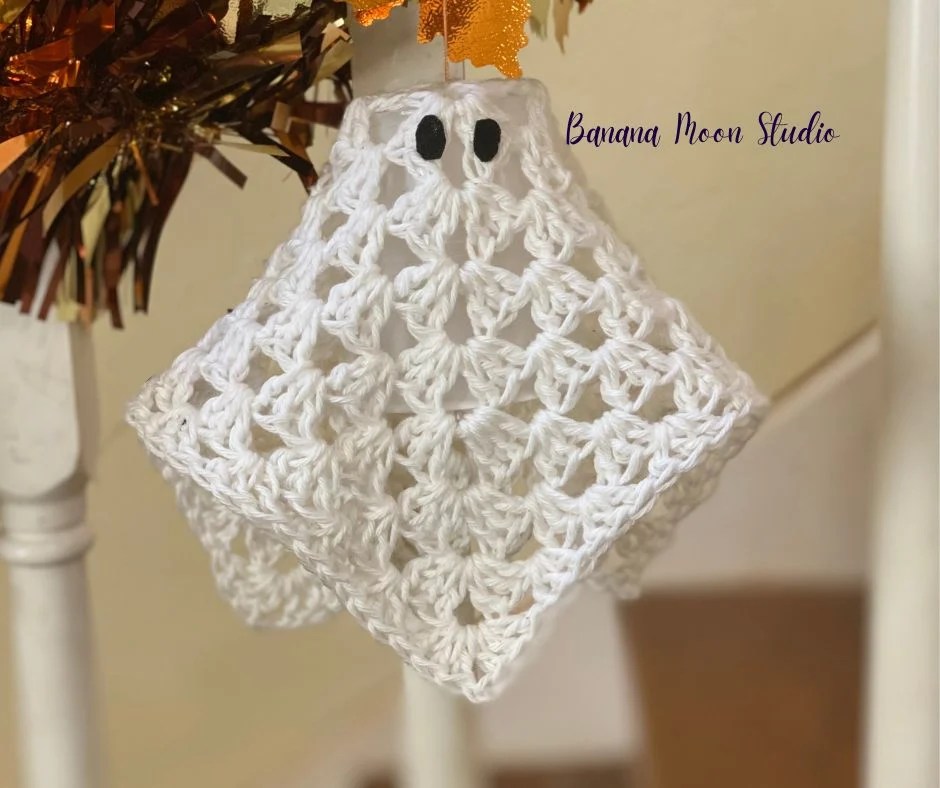Granny square crochet ghost. Shown in white on a stair banister. 