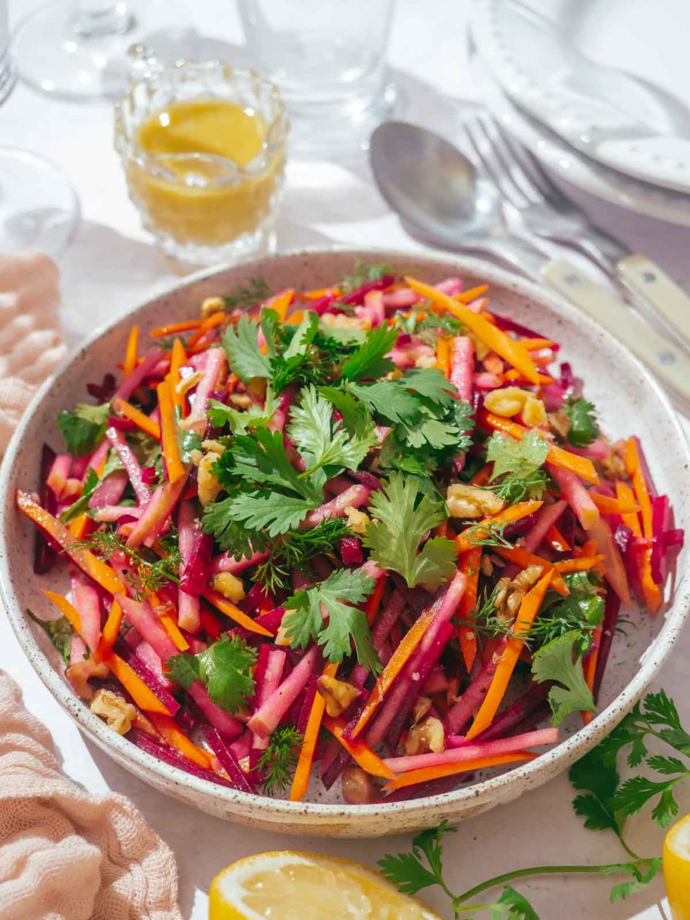 Beet and carrot salad on a plate, topped with fresh cilantro.