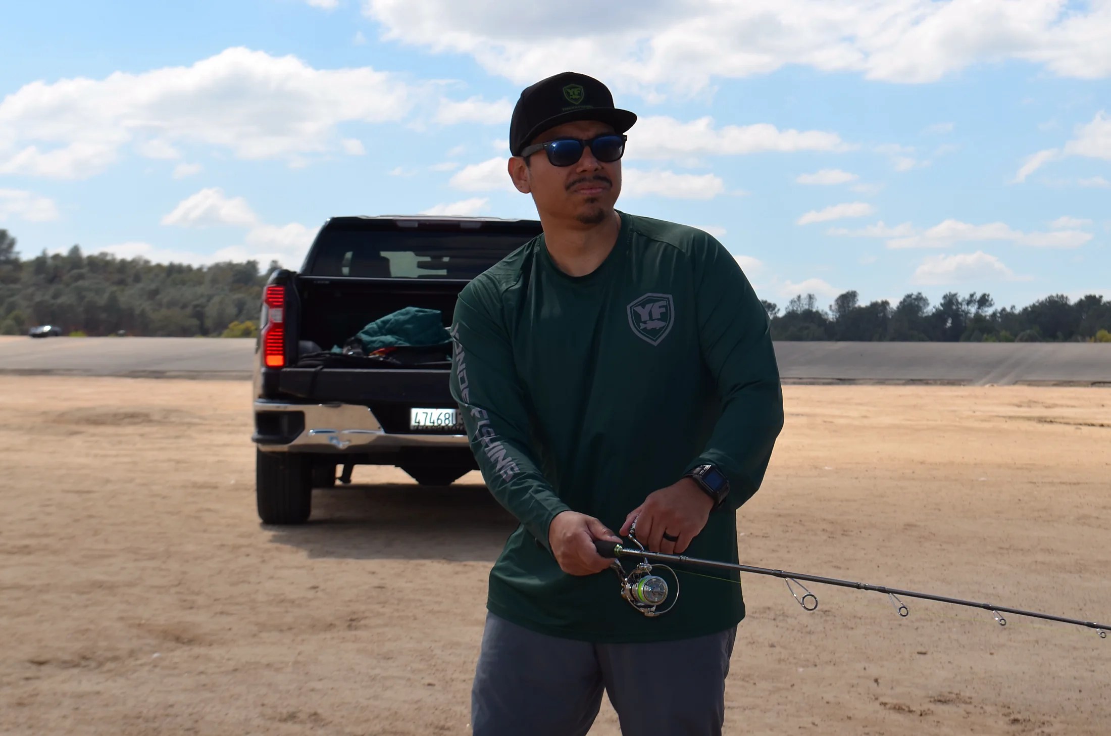 Angler holding the EdgeWalker 66MHT travel rod beside a pickup truck