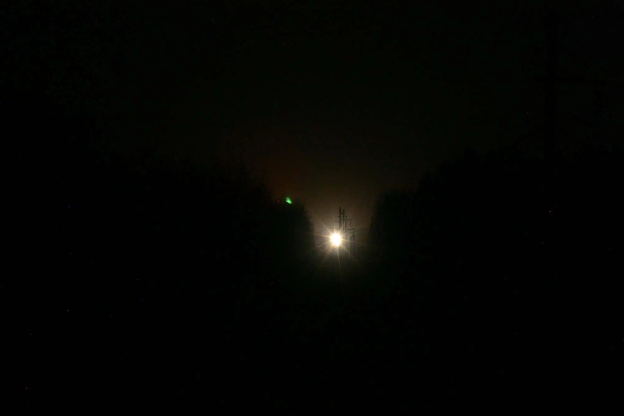 The Paulding Light, a distant glow above the tree line at night.