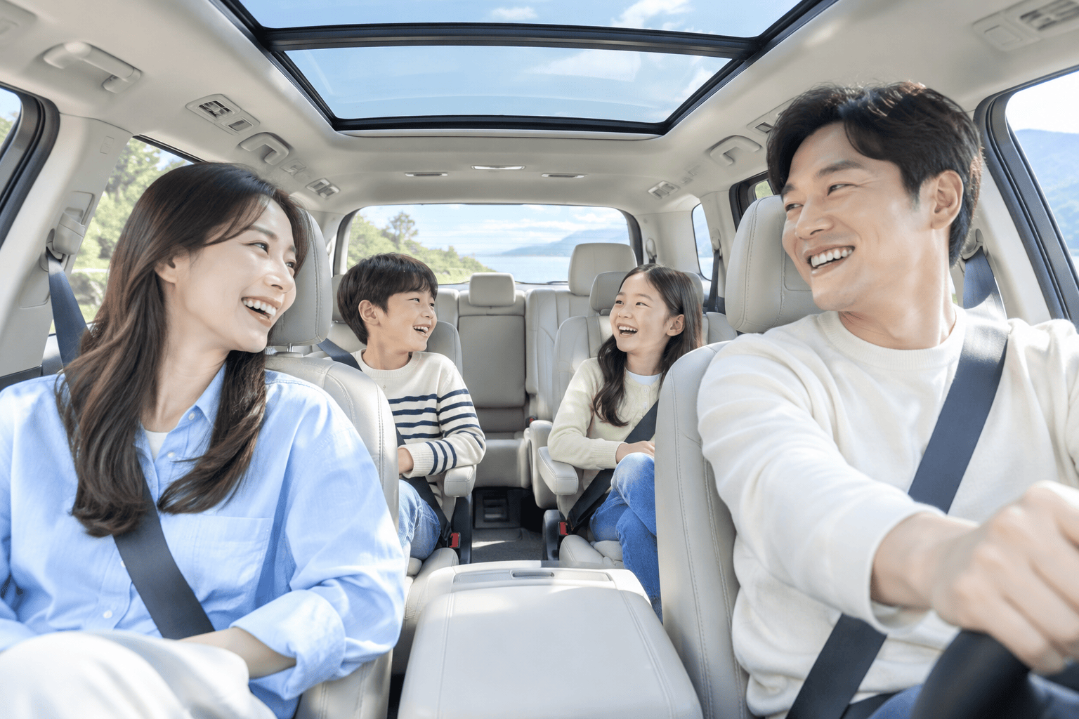 넓은 실내 공간의 가족 차량 내부에서 가족 구성원들이 편안하게 앉아 있는 모습