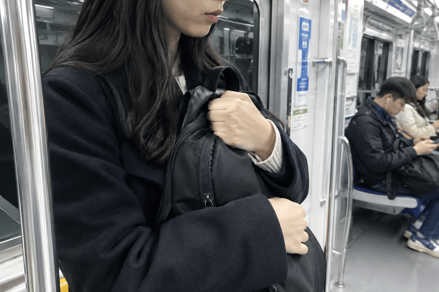 혼잡한 지하철에서 소지품을 안전하게 관리하는 승객