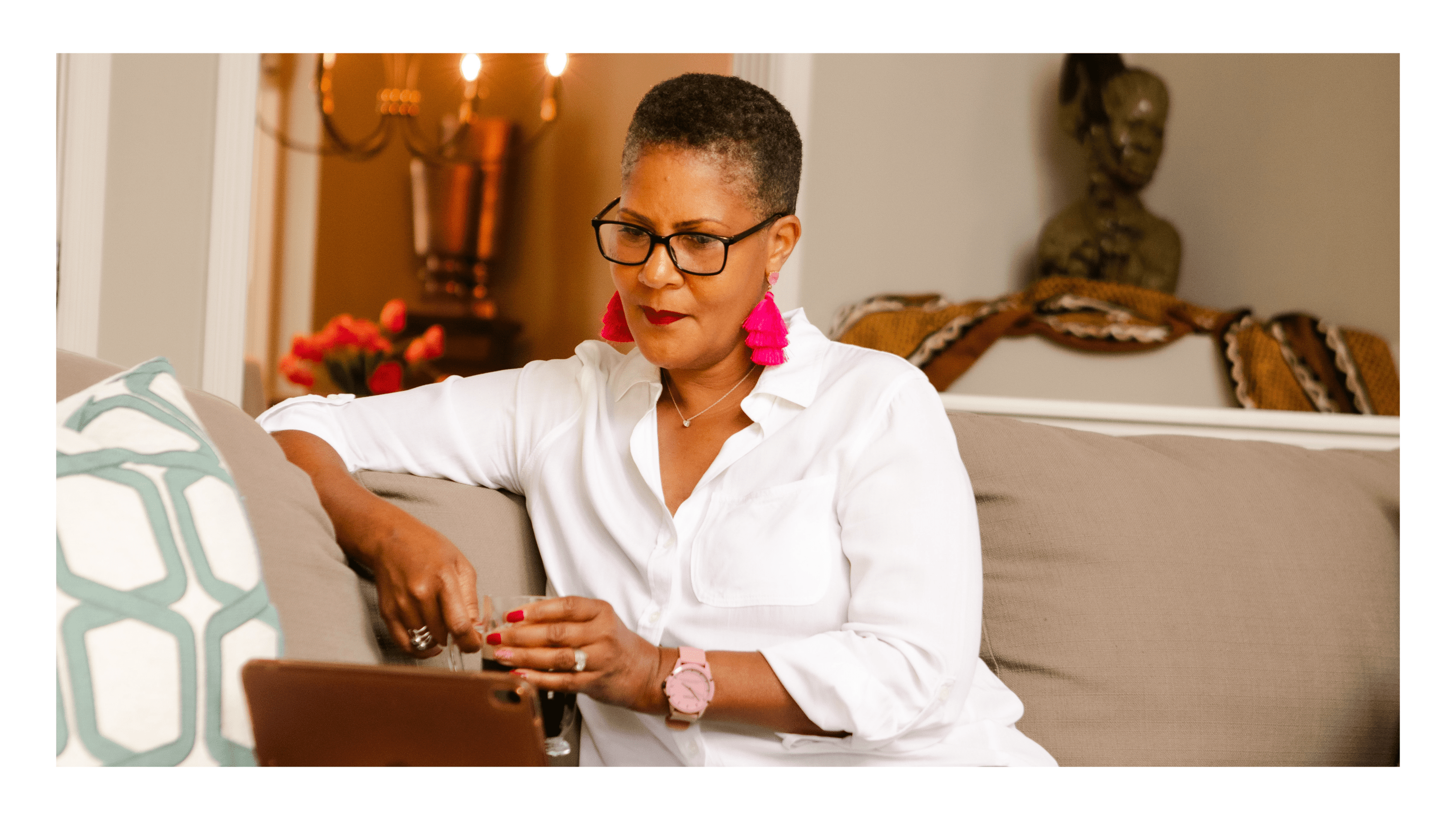 woman sitting on a sofa with coffee and an ipad working