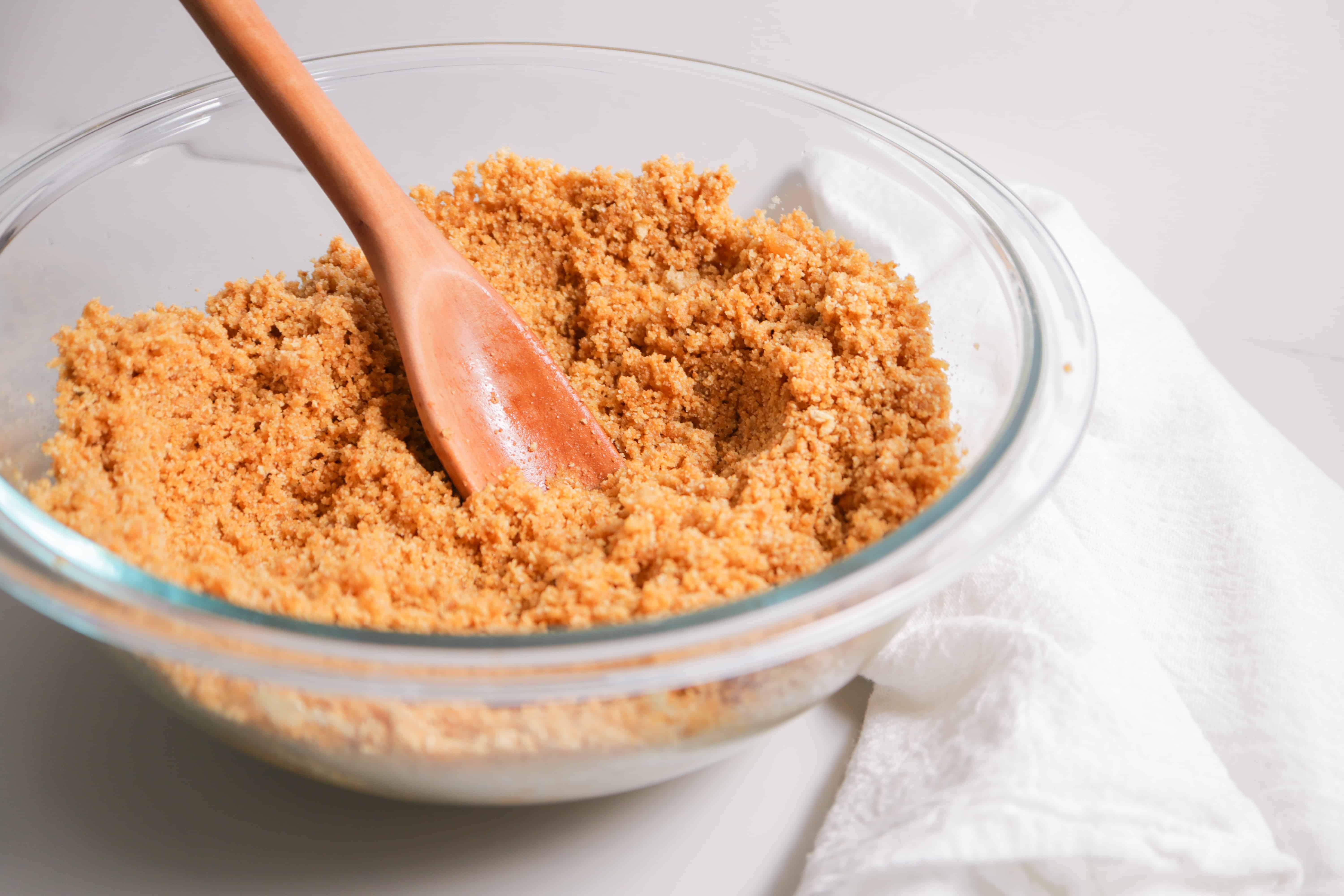 wooden spoon in graham cracker crumb mixture