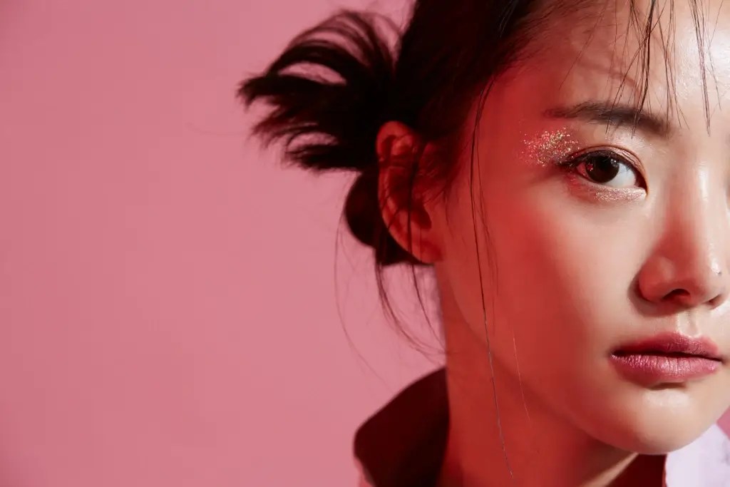 A idol from Japan against a pink background.