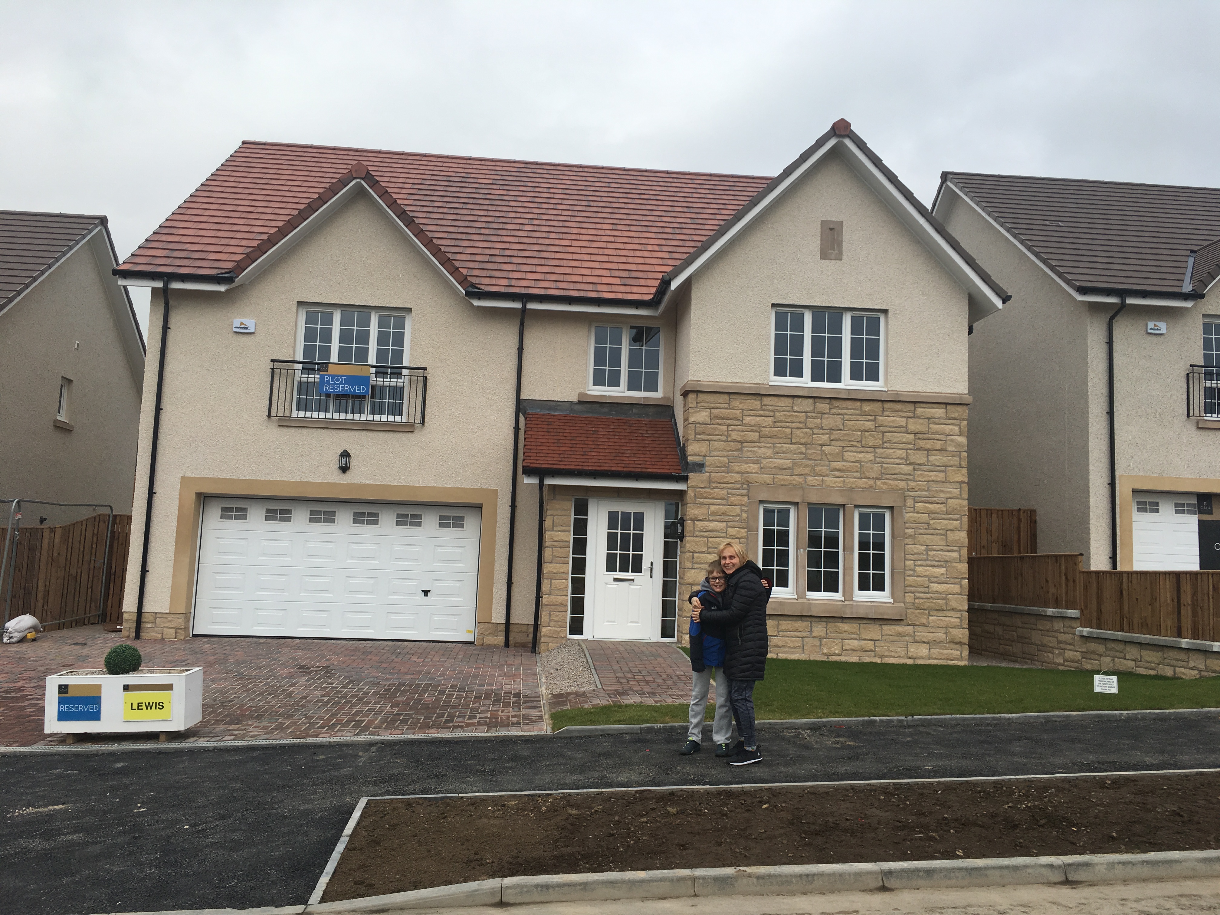 mum and son in front of new home
