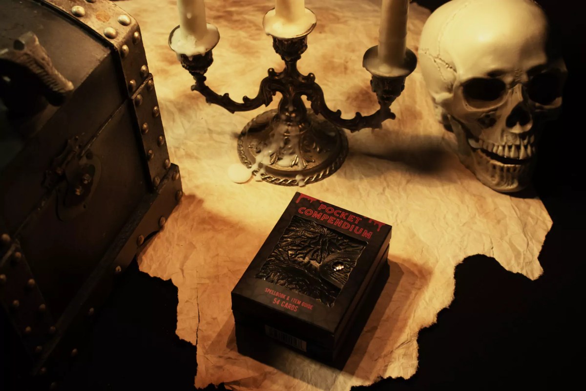Zack Marsh Design, pocket compendium product photography of product packaging on torn parchment with horror props around it