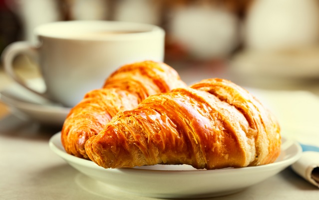 breakfast with croissants, cup of black coffee and newspaper