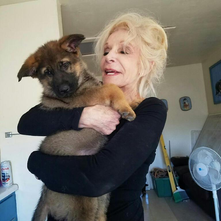 A woman holding a dog in her arms.