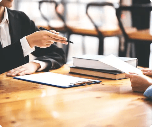 Dos personas a una mesa leyendo y firmando un contrato