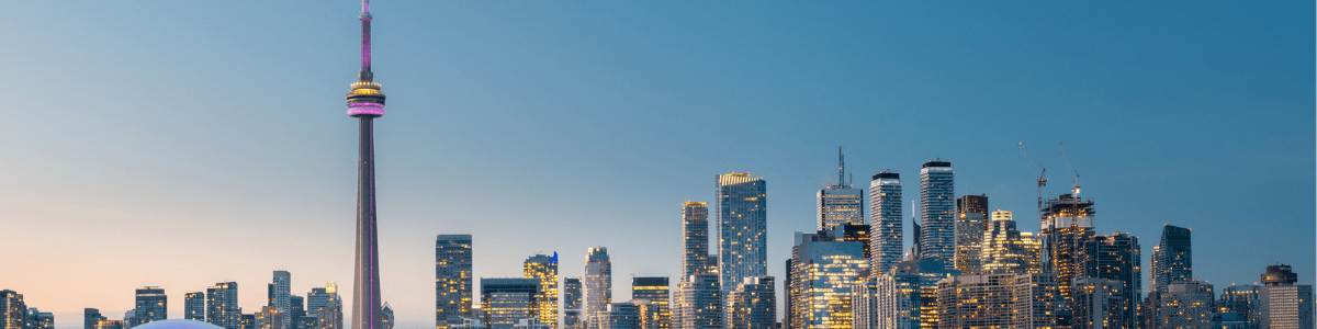 Skyline de Toronto al atardecer con la Torre CN y rascacielos iluminados.