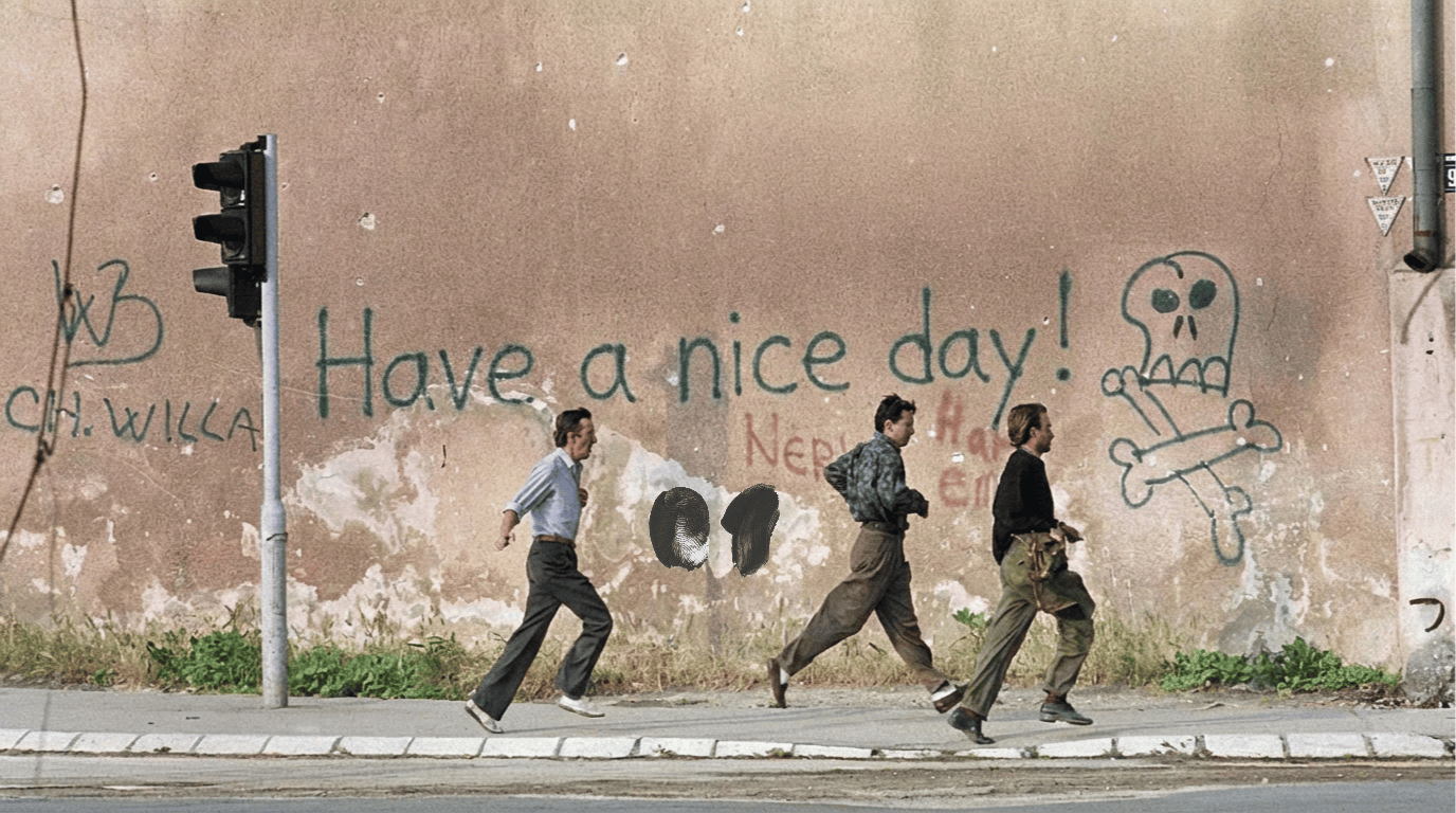 Street scene in war damaged Sarajevo with graffiti reading "Have a nice day" next to a skull symbol, contrasting positivity with a context of conflict