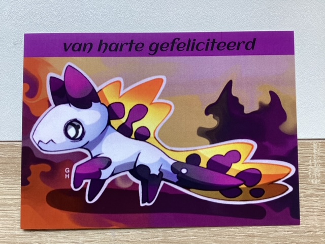 Op de kaart staat een schattige blauwe en paarse monster . De achtergrond is geel, oranje en paars. Aan de bovenkant van de kaart staat: van harte gefeliciteerd.